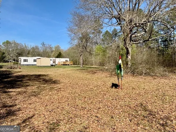 a view of a yard with wooden fence