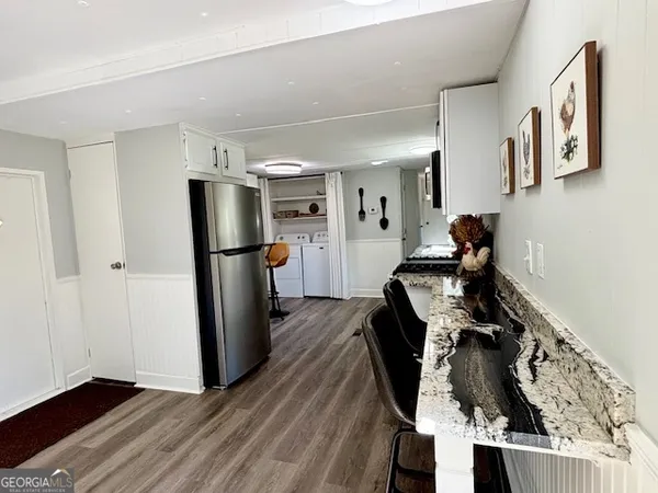 a kitchen with a refrigerator and wooden floor