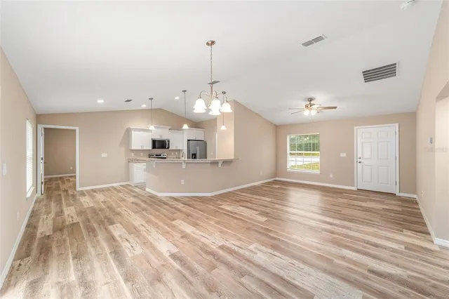 a view of a kitchen with kitchen island sink and wooden floor