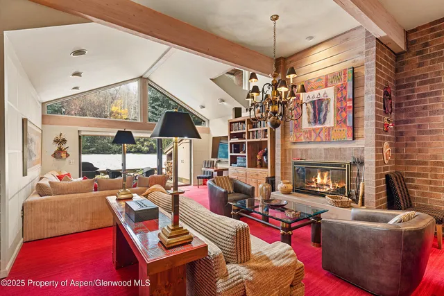 a living room with furniture a chandelier and a fireplace