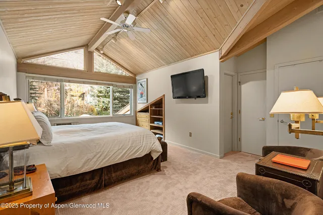 a bedroom with furniture and a flat screen tv