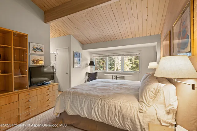 a spacious bedroom with a bed and a window