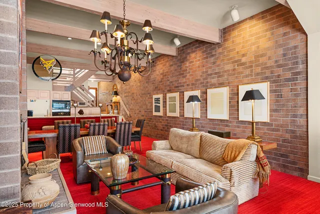 a living room with furniture a chandelier and a dining table