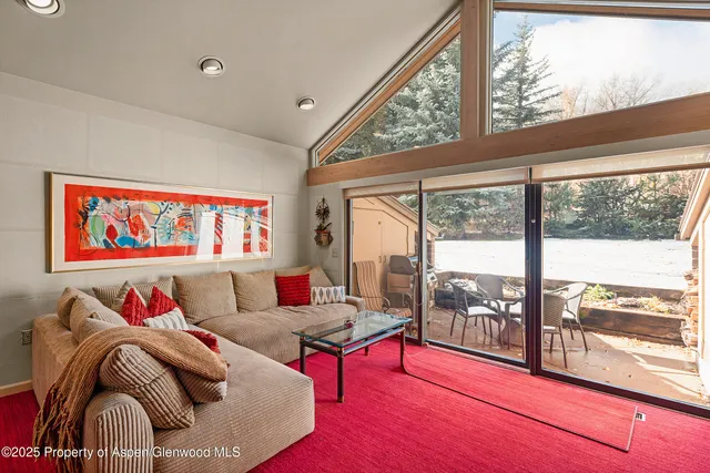 a living room with furniture and a floor to ceiling window