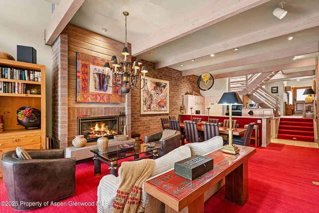 a living room with furniture a fireplace and a chandelier