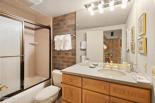a bathroom with a sink toilet double vanity and shower