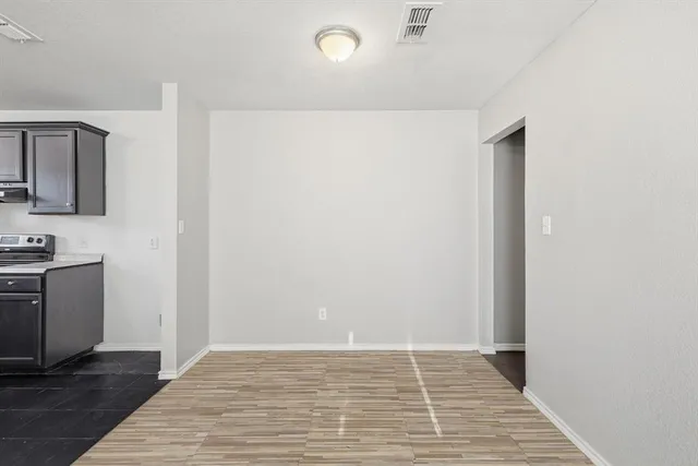 a view of a room with wooden floor and electronic appliances