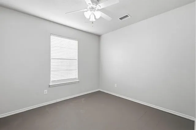 an empty room with a window and a fan
