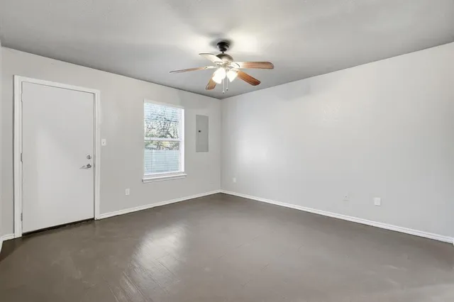an empty room with windows and fan