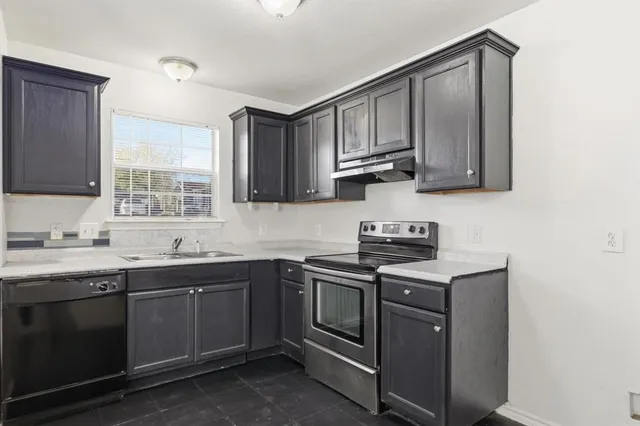 a kitchen with stainless steel appliances granite countertop a sink stove and cabinets