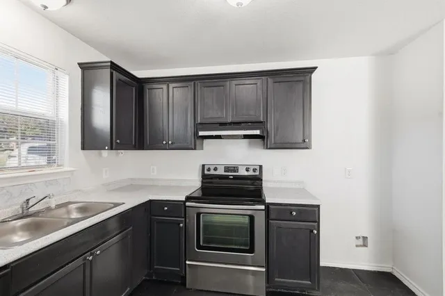 a kitchen with sink cabinets and stainless steel appliances
