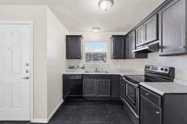 a kitchen with stainless steel appliances granite countertop a sink stove and cabinets