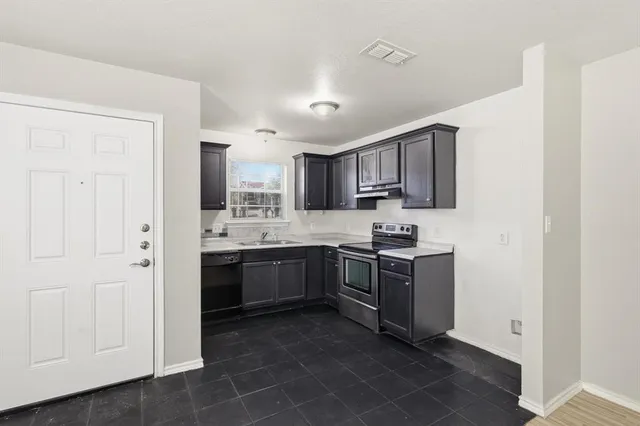 a kitchen with stainless steel appliances granite countertop a stove top oven a sink and dishwasher