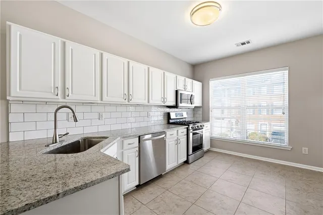 a kitchen with a sink stove and cabinets