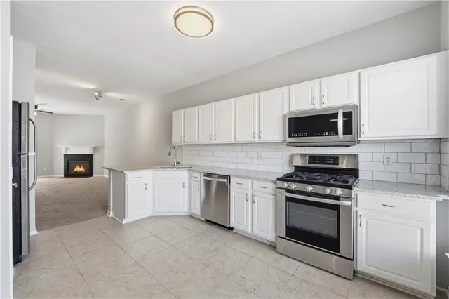 a kitchen with cabinets stainless steel appliances and wooden floor