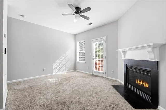 a view of an empty room with window and fireplace