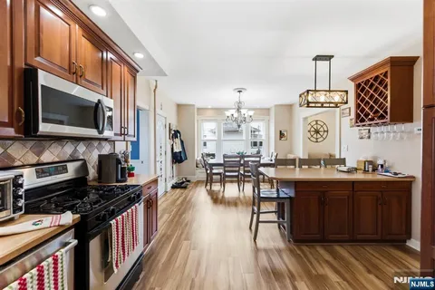 a kitchen with stainless steel appliances a stove top oven a sink dishwasher and cabinets with wooden floor