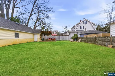 a view of an house with backyard and a tree
