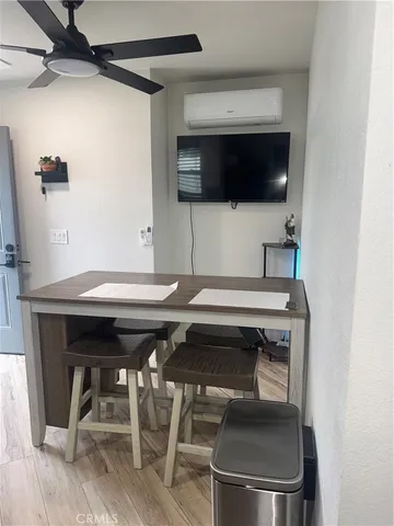 a living room with a table chairs and a microwave