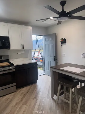 a kitchen with kitchen island stainless steel appliances wooden floor dining table and chairs