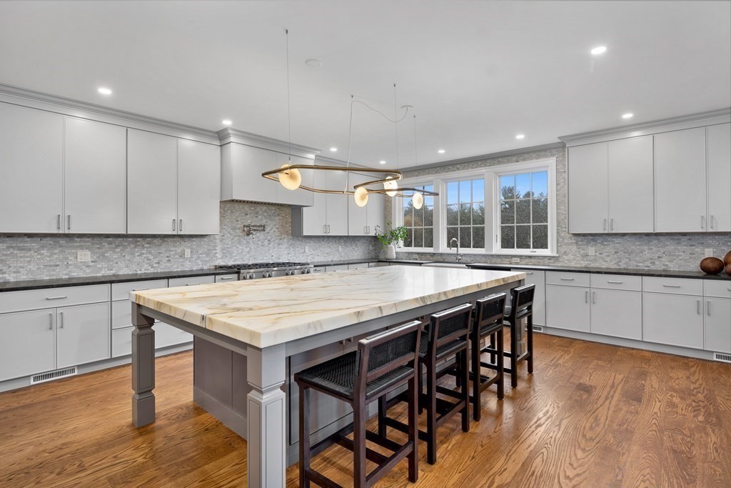 98 Heather Lane Needham, MA 02492 - Photo 19 of 31 a kitchen with stainless steel appliances granite countertop a kitchen island a stove and a sink