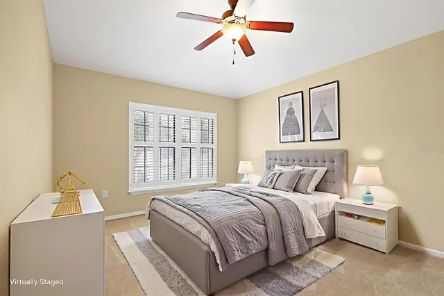 an empty room with chandelier fan and windows