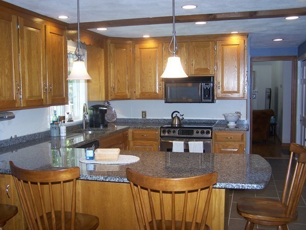 40 Porter Road Boxford, MA 01921 - Photo 5 of 16 a kitchen with stainless steel appliances granite countertop a sink a stove top oven a dining table and chairs