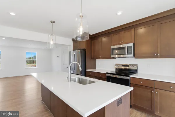 a kitchen that has a sink stainless steel appliances a counter space and cabinets