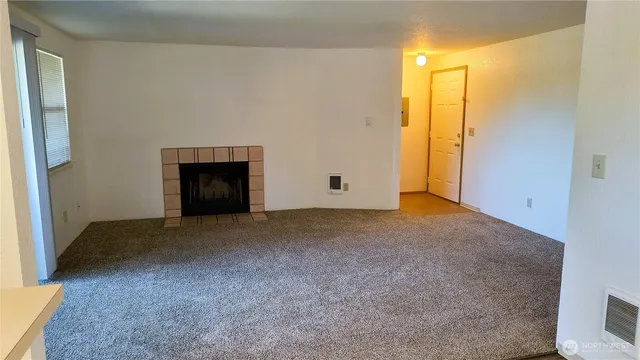 a view of empty room with a fireplace
