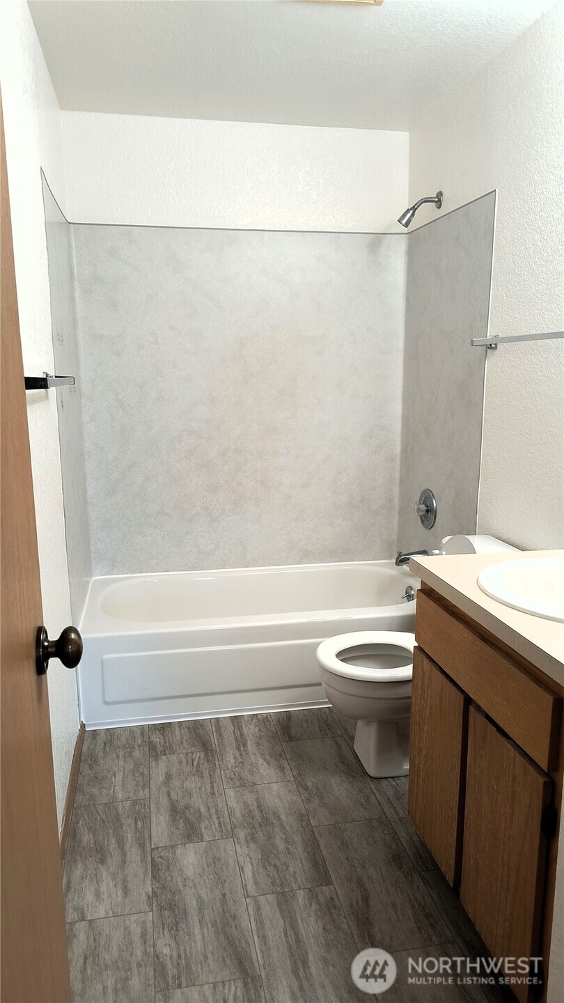 13232 Ambaum Boulevard Southwest Burien, WA 98146 - Photo 19 of 22 a bathroom with a granite countertop bathtub shower sink vanity and toilet