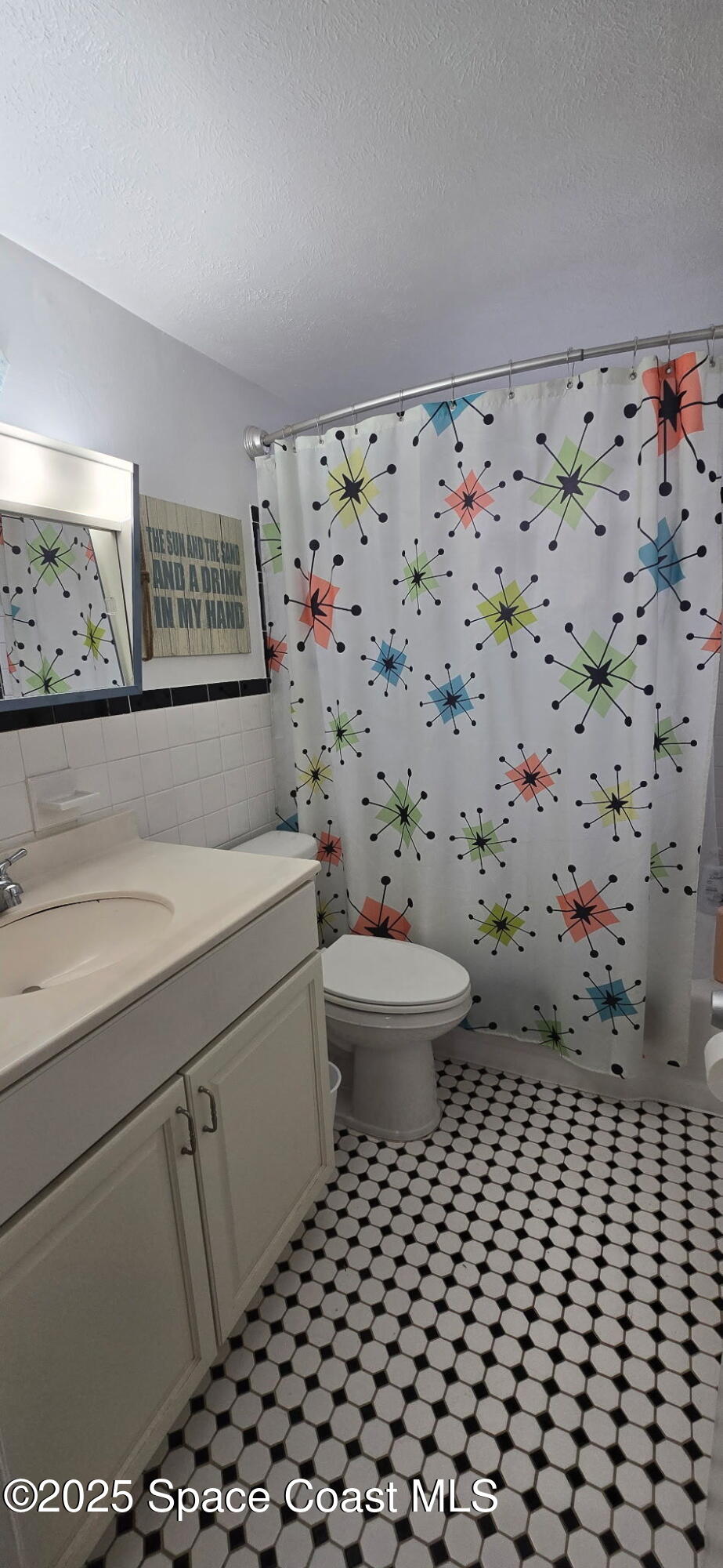 415 Madison Avenue, Unit I102 Cape Canaveral, FL 32920 - Photo 11 of 29 a bathroom with a toilet and a shower curtain