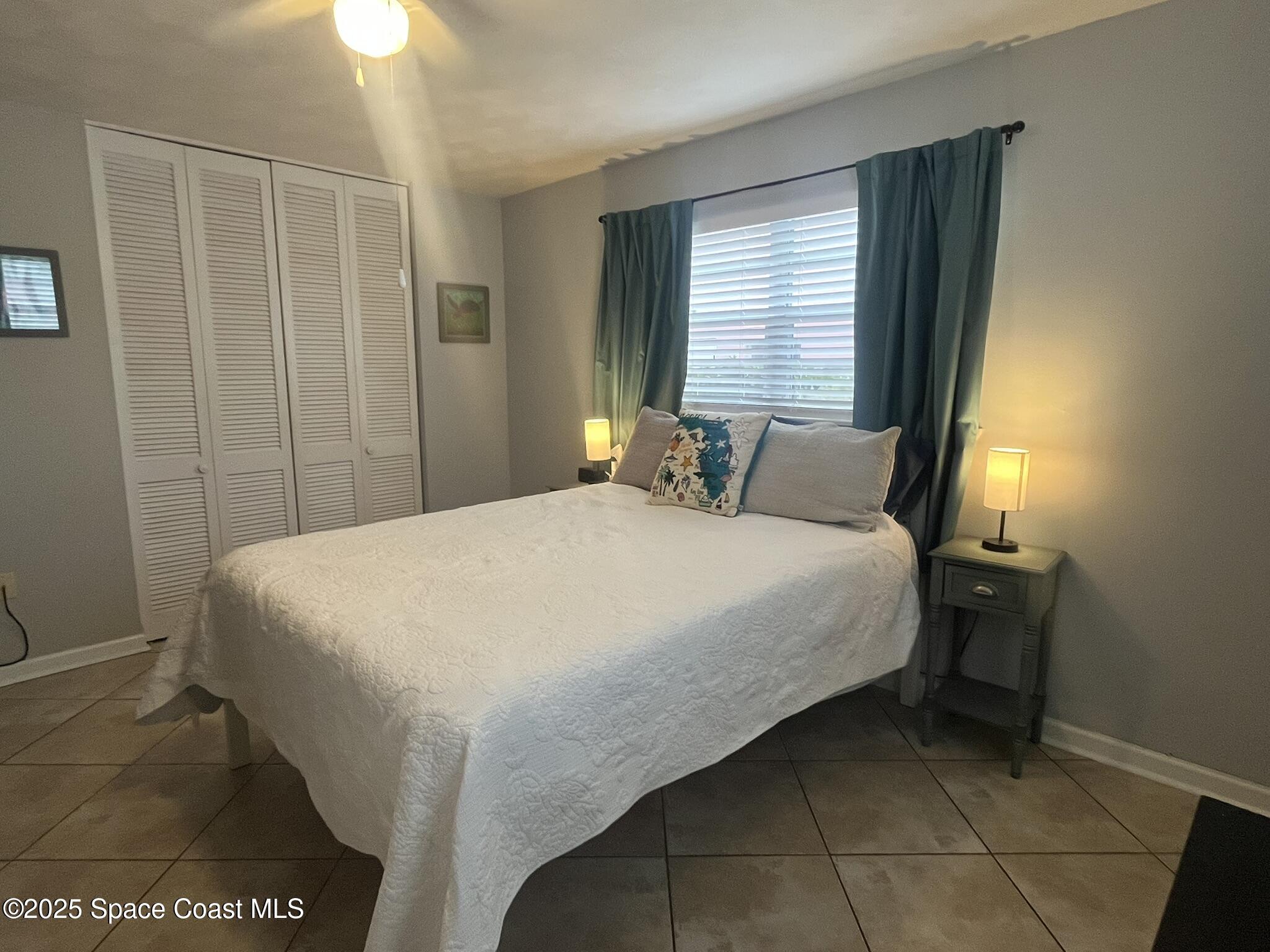 415 Madison Avenue, Unit I102 Cape Canaveral, FL 32920 - Photo 16 of 29 a bedroom with a bed and a window