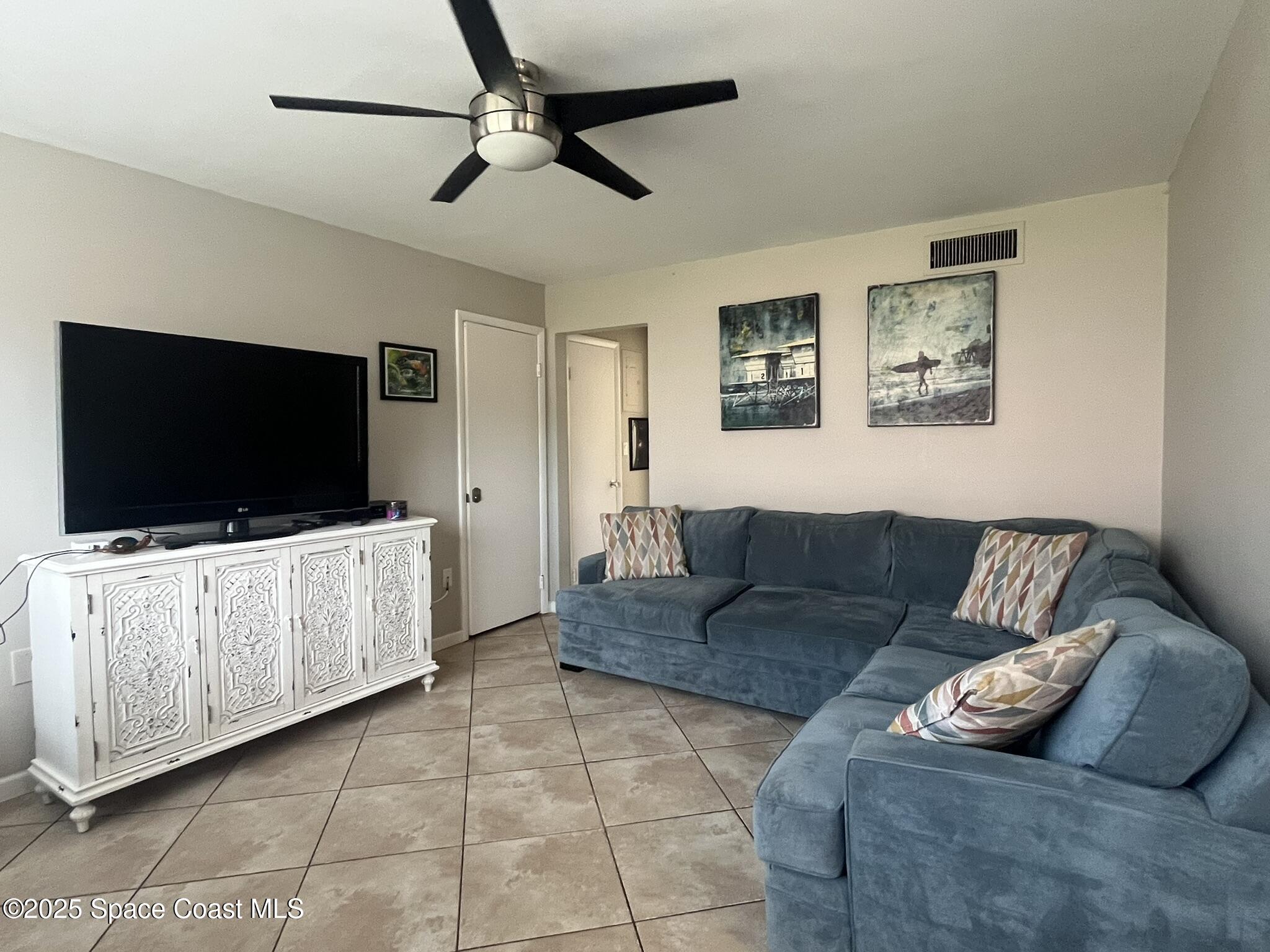 415 Madison Avenue, Unit I102 Cape Canaveral, FL 32920 - Photo 21 of 29 a living room with furniture and a flat screen tv