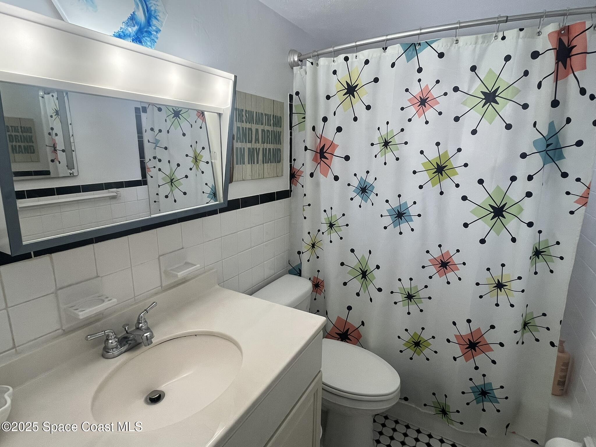 415 Madison Avenue, Unit I102 Cape Canaveral, FL 32920 - Photo 4 of 29 a bathroom with a sink and a mirror