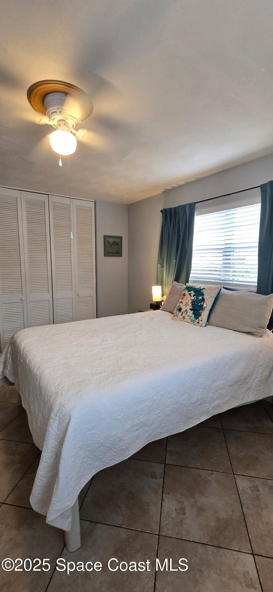 415 Madison Avenue, Unit I102 Cape Canaveral, FL 32920 - Photo 8 of 29 a bedroom with a bed and a night stand