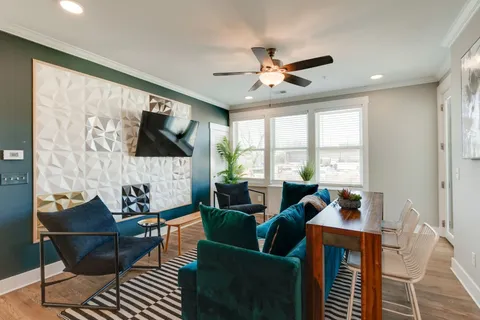 a living room with furniture a flat screen tv and a large window