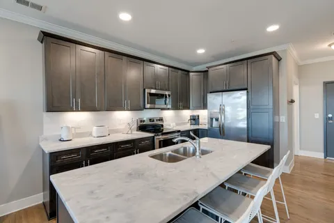a kitchen with a table chairs refrigerator and cabinets