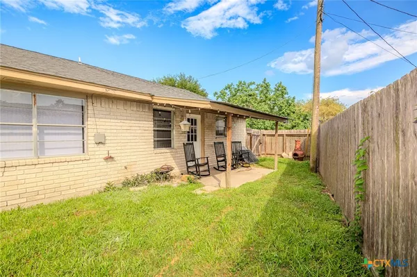 a view of a house with backyard and sitting area