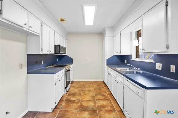 a kitchen with stainless steel appliances granite countertop a sink stove and cabinets