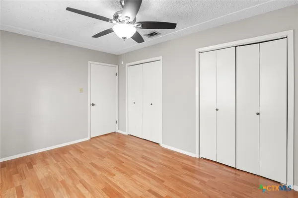 a view of empty room with wooden floor