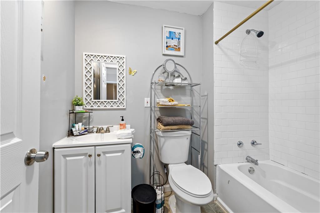 2220 Lee Street Southwest Covington, GA 30014 - Photo 14 of 30 a bathroom with a toilet sink vanity tub and mirror