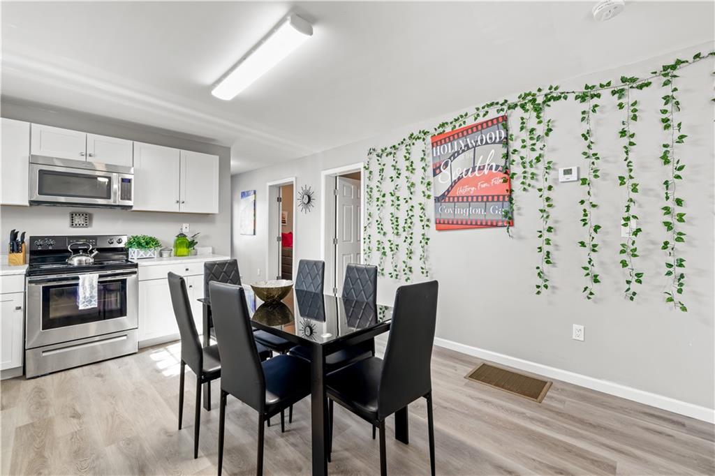 2220 Lee Street Southwest Covington, GA 30014 - Photo 5 of 30 a view of a dining room with furniture and wooden floor