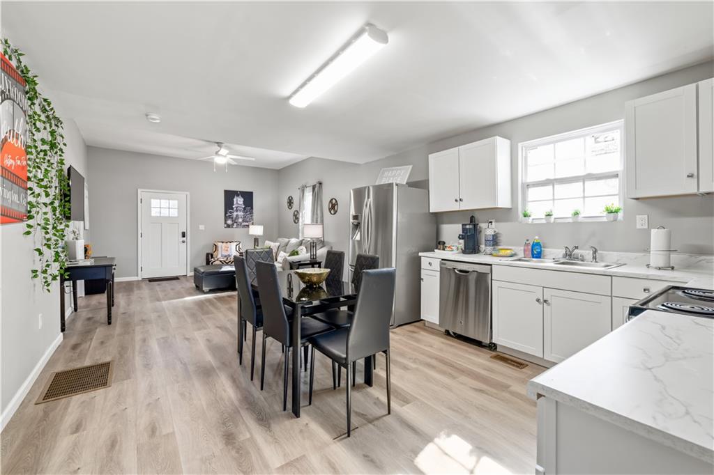2220 Lee Street Southwest Covington, GA 30014 - Photo 9 of 30 a kitchen with white cabinets and chairs