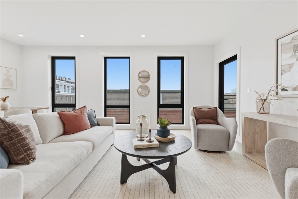 118 B Street, Unit 408 Boston, MA 02127 - Photo 2 of 11 a living room with furniture and a table