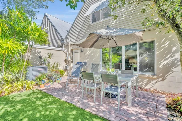 a view of a patio with table and chairs under an umbrella