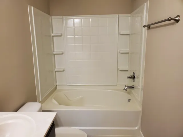 an empty room with closet and a chandelier fan