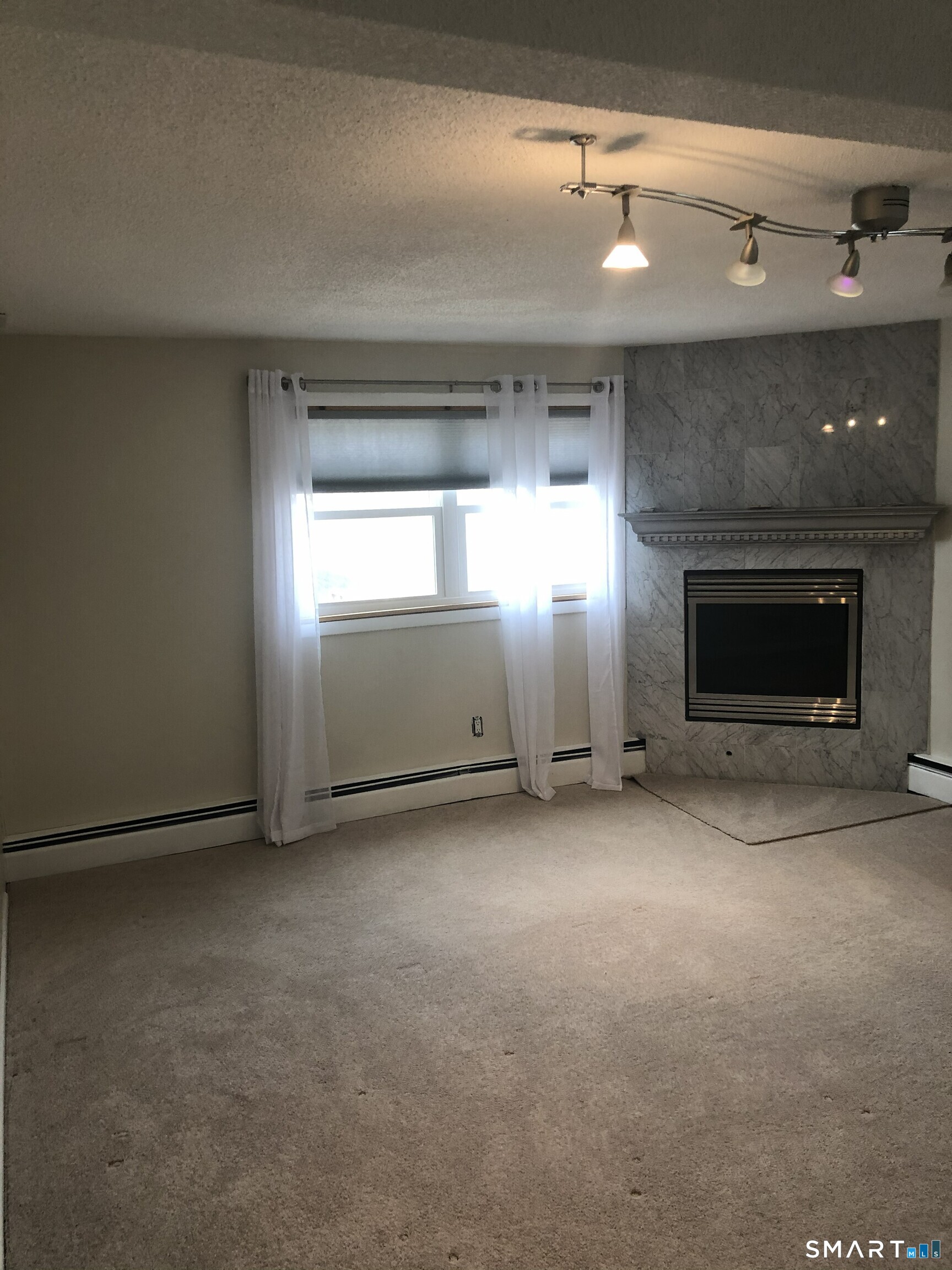 311 Racebrook Road Orange, CT 06477 - Photo 4 of 12 an empty room with windows and fireplace
