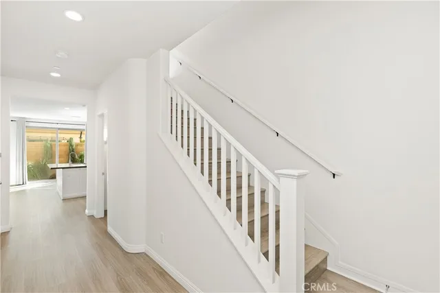 a view of a hallway with wooden floor and staircase