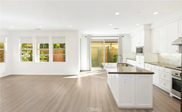 a kitchen with stainless steel appliances granite countertop a sink and a large window