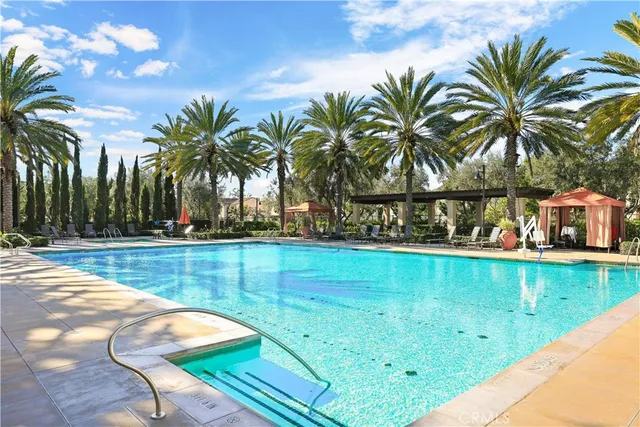 a view of swimming pool with a yard and palm trees